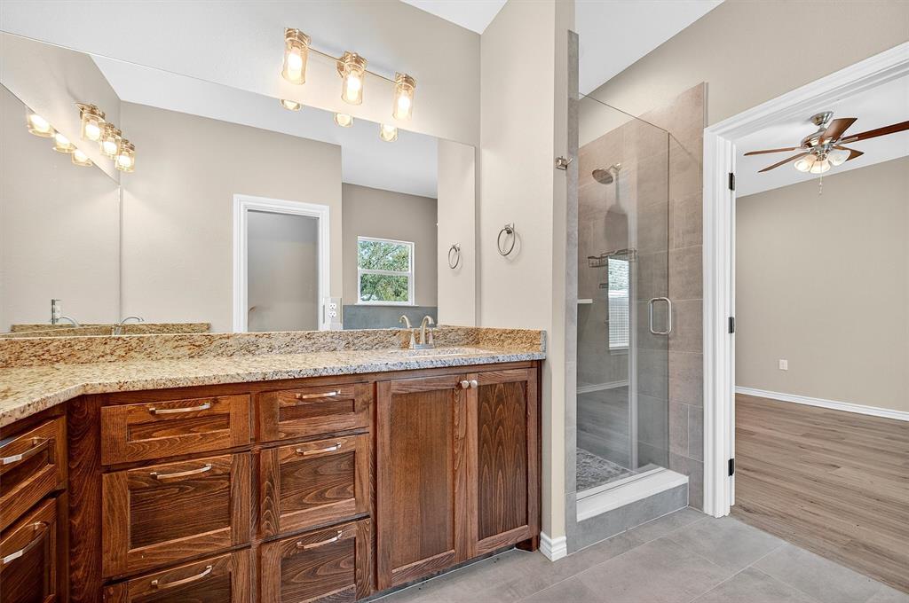 508 Goodjohn Street Collinsville, TX 76233 - Photo 23 of 40 Bathroom with light tile patterned floors, a stall shower, ceiling fan, and double vanity