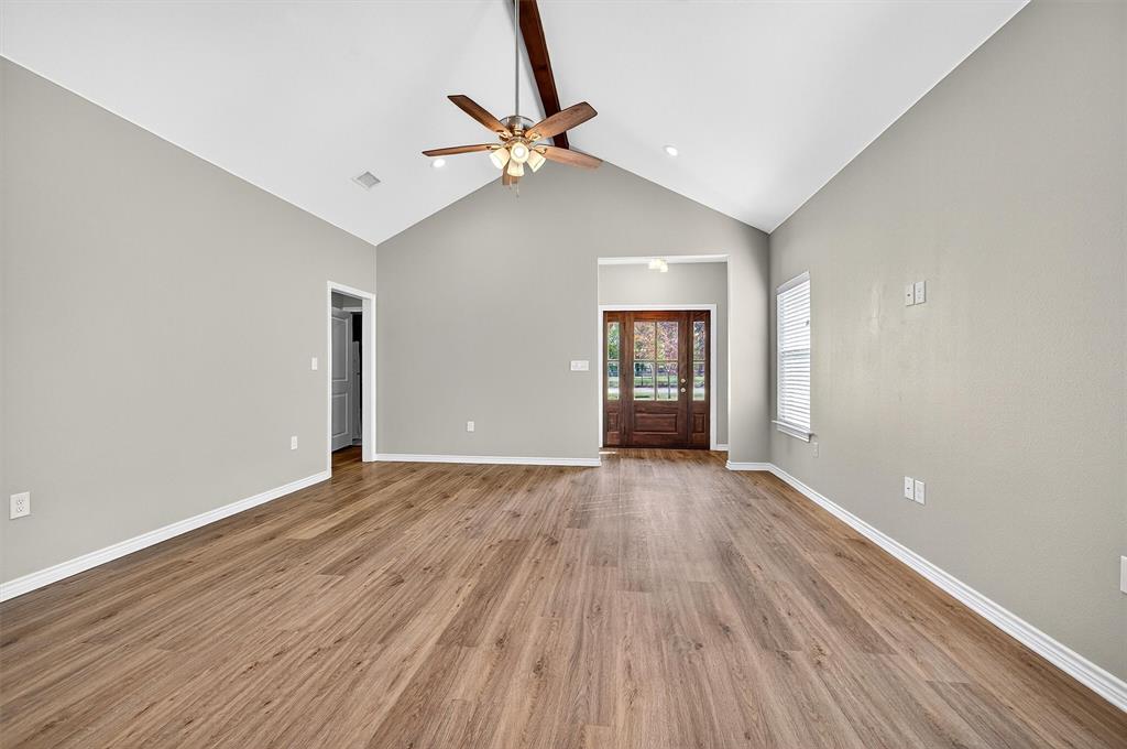 508 Goodjohn Street Collinsville, TX 76233 - Photo 3 of 40 Unfurnished living room with high vaulted ceiling, light wood finished floors, beamed ceiling, and a ceiling fan