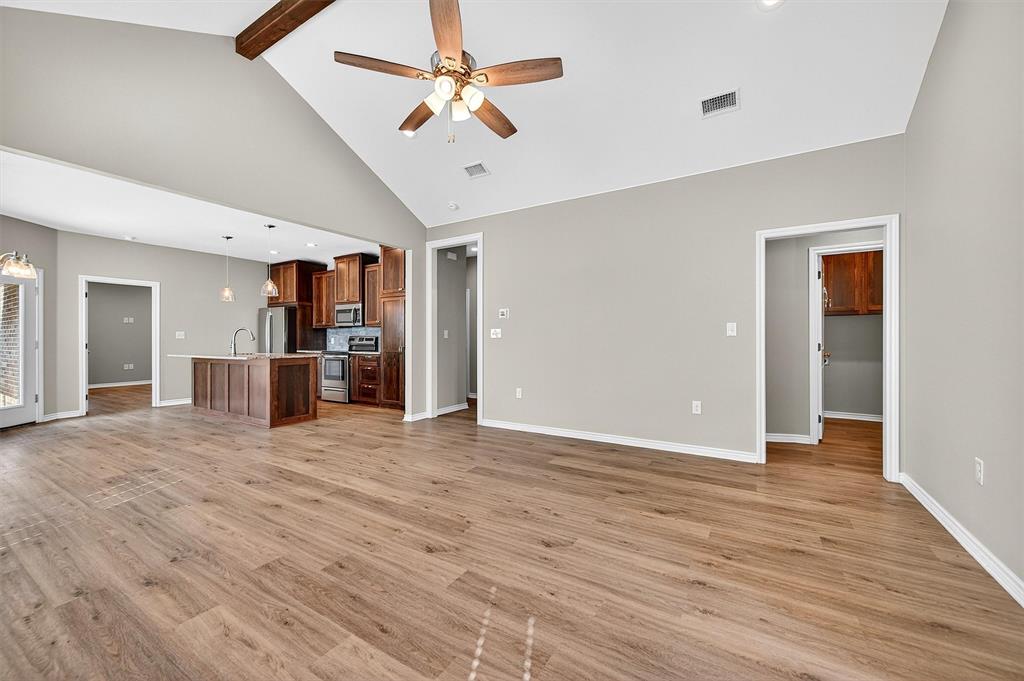 508 Goodjohn Street Collinsville, TX 76233 - Photo 4 of 40 Unfurnished living room with light wood finished floors, high vaulted ceiling, a ceiling fan, and beamed ceiling