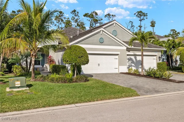 a front view of a house with a yard and potted plants