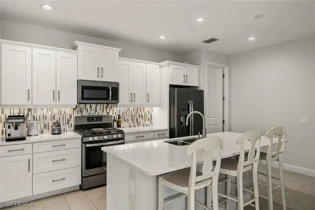 a kitchen with white cabinets and stainless steel appliances