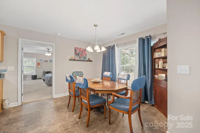 a dining room with furniture a chandelier and window