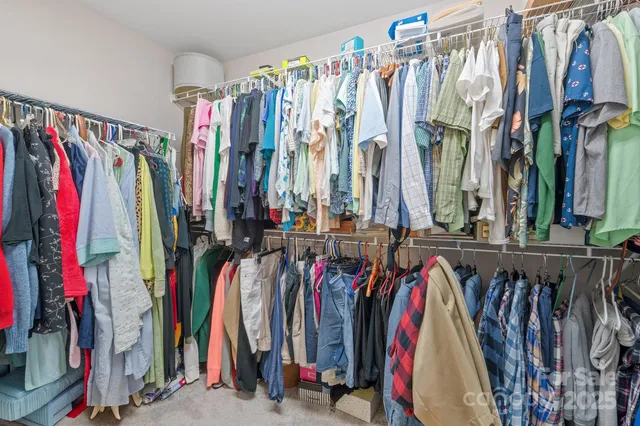 a view of walk in closet with clothes
