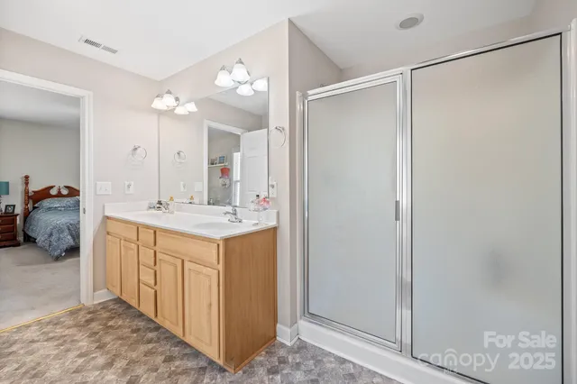 a bathroom with a double vanity sink mirror and shower