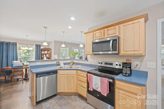 a kitchen with stainless steel appliances granite countertop a stove a sink and a microwave