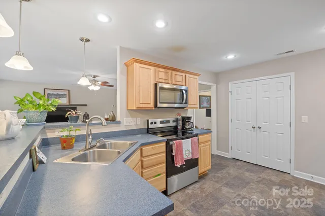 a kitchen with granite countertop a sink a counter top space and cabinets