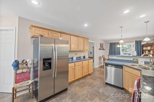 a kitchen with stainless steel appliances granite countertop a refrigerator and a sink