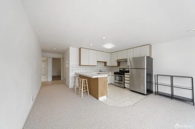 a view of kitchen with refrigerator stove microwave and cabinets