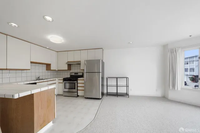 a kitchen with stainless steel appliances granite countertop a stove a sink and a refrigerator