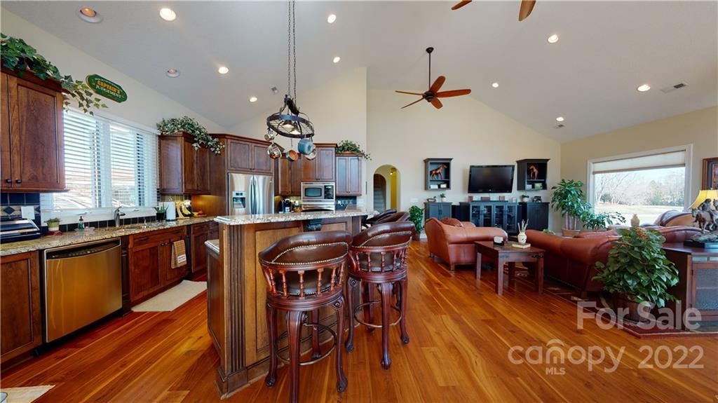 3908 Thompson Road Lancaster, SC 29720 - Photo 16 of 36 a kitchen with stainless steel appliances granite countertop a refrigerator a stove top oven a dining table and chairs with wooden floor