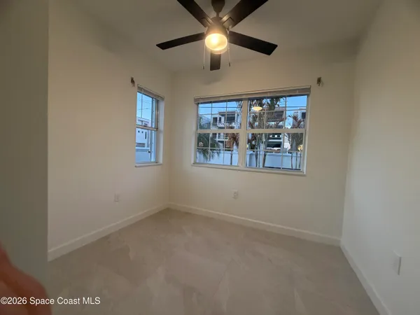 an empty room with ceiling fan and window