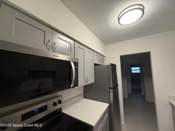 a kitchen with stainless steel appliances a refrigerator microwave and sink