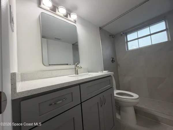 a bathroom with a double vanity sink toilet and a mirror