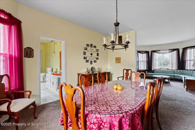 a dining room with furniture a chandelier and wooden floor