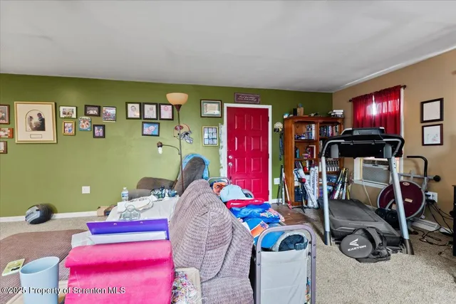 a living room with furniture a flat screen tv and a floor to ceiling window