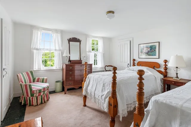 a bed room with two bed and a chair