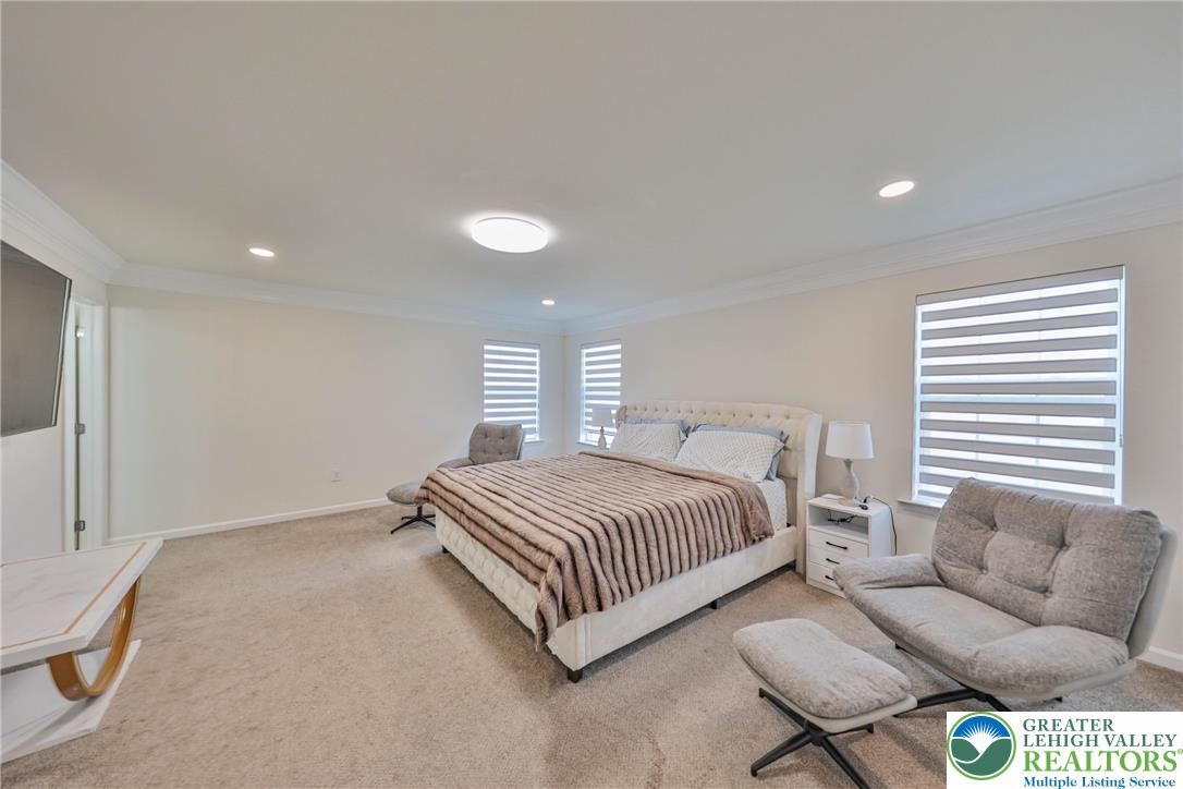 1105 Meco Road Easton, PA 18040 - Photo 43 of 100 Plush carpeting and crown molding elevate this serene, light-filled primary suite.