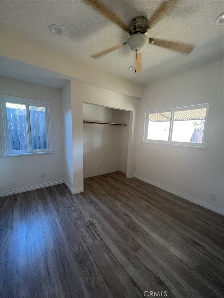 2228 Ridgeview Terrace Corona, CA 92882 - Photo 7 of 12 an empty room with wooden floor cabinet and windows