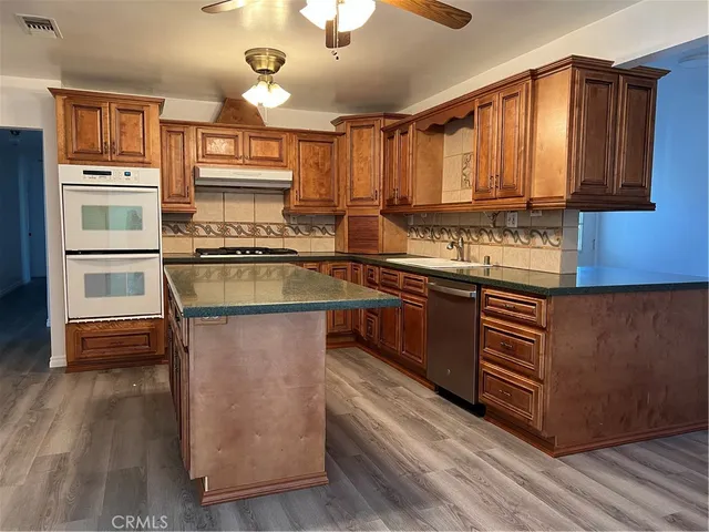 a kitchen with stainless steel appliances granite countertop a stove a sink dishwasher and a refrigerator