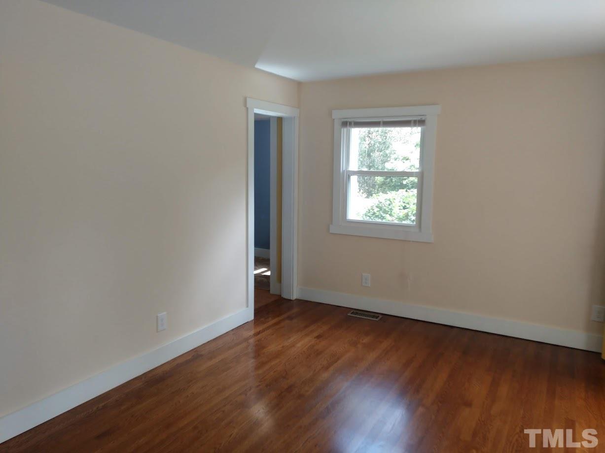 2521 Remington Road Raleigh, NC 27610 - Photo 3 of 30 an empty room with wooden floor and windows