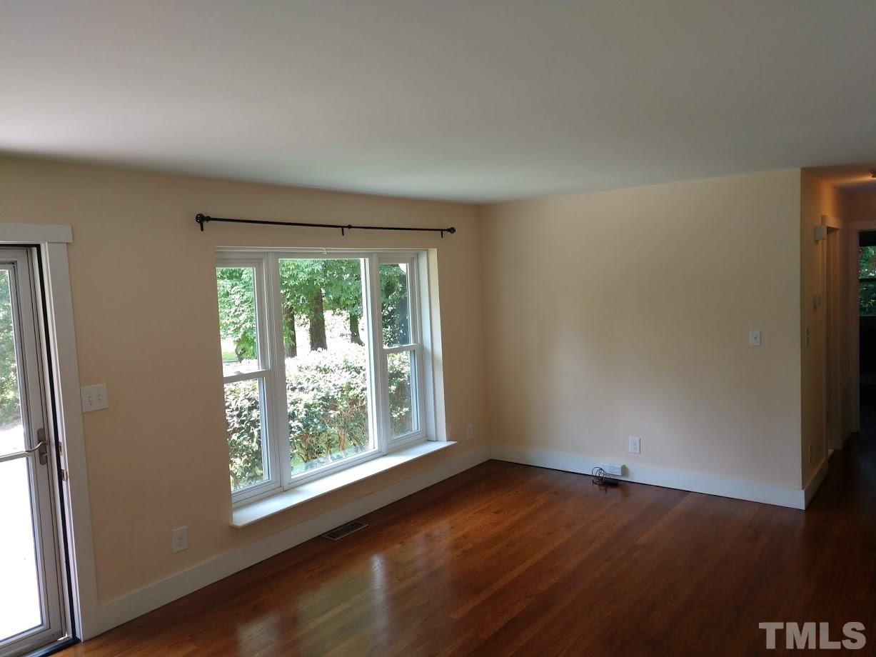 2521 Remington Road Raleigh, NC 27610 - Photo 5 of 30 an empty room with wooden floor and windows