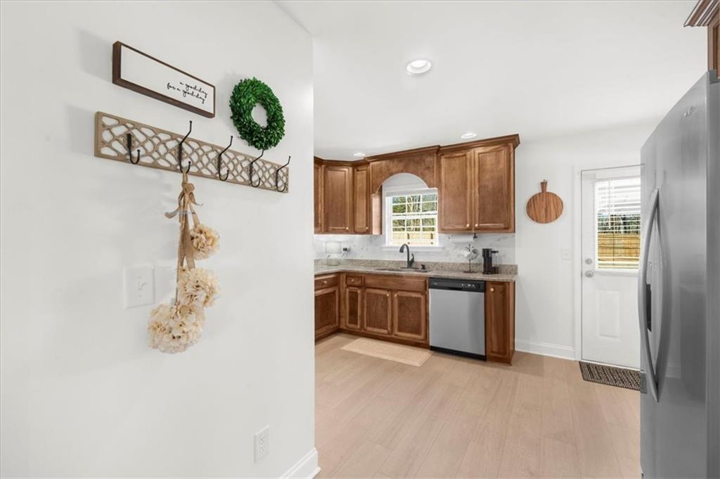 5413 Stepstone Way Gainesville, GA 30506 - Photo 13 of 36 a kitchen with stainless steel appliances granite countertop a sink and a wooden floor