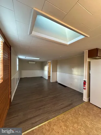 a view of an empty room with wooden floor and closet