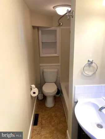 a white toilet sitting next to a bath tub
