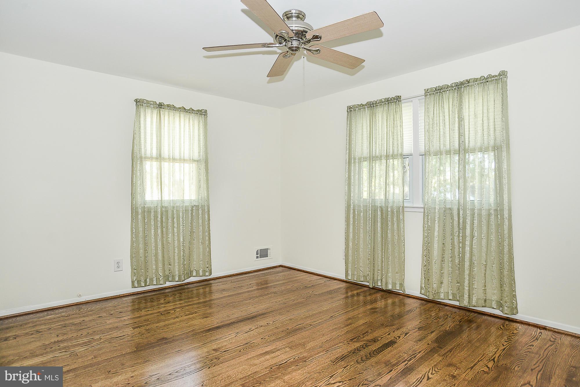 8140 Drayton Lane Springfield, VA 22151 - Photo 11 of 30 an empty room with wooden floor fan and windows