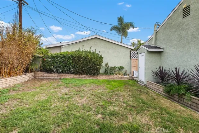a view of a house with a yard and potted plants