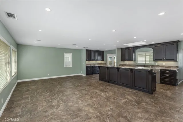 a large kitchen with a large counter top stainless steel appliances and cabinets