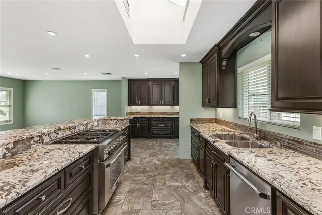 a kitchen with granite countertop a sink and a stove