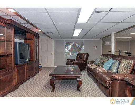 23 Tamarack Road Edison, NJ 08820 - Photo 20 of 23 a living room with furniture a flat screen tv and a table