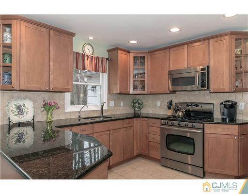 23 Tamarack Road Edison, NJ 08820 - Photo 6 of 23 a kitchen with stainless steel appliances granite countertop a stove a sink dishwasher and a microwave