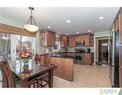 23 Tamarack Road Edison, NJ 08820 - Photo 7 of 23 a kitchen with stainless steel appliances kitchen island granite countertop a dining table chairs and a refrigerator