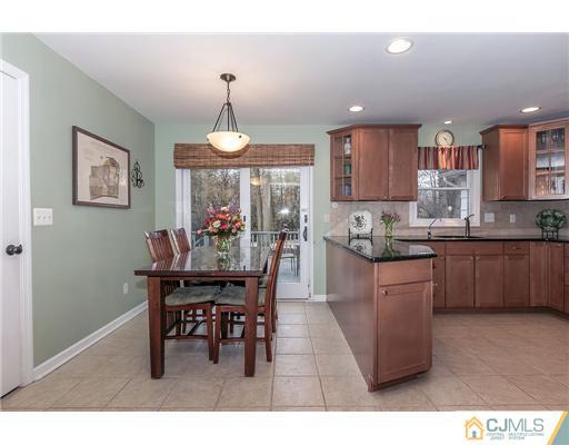 23 Tamarack Road Edison, NJ 08820 - Photo 8 of 23 a kitchen with stainless steel appliances granite countertop a dining table chairs and a refrigerator