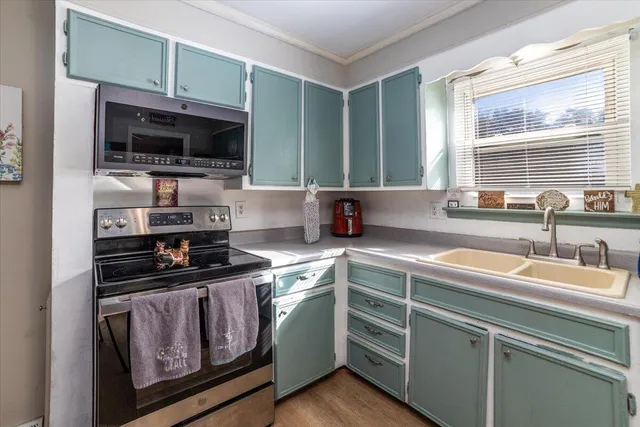 a kitchen with stainless steel appliances a stove sink microwave and cabinets