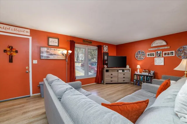 a living room with furniture a flat screen tv and floor to ceiling window