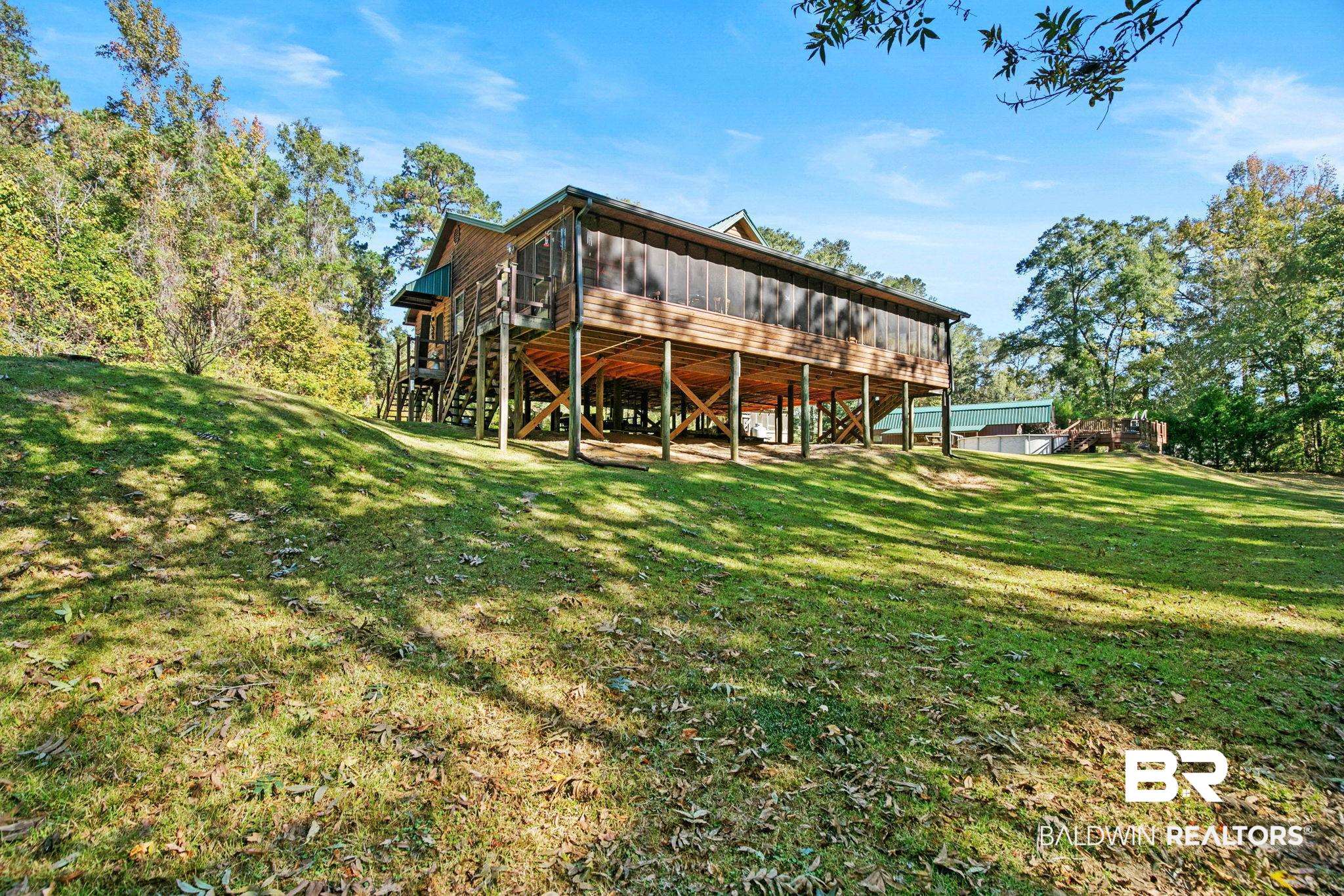 724 Rowell Lane Brewton, AL 36426 - Photo 5 of 40 Back of house with a yard, stairway, a wooden deck, and board and batten siding