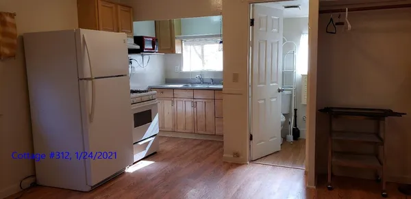 a kitchen with granite countertop a refrigerator and a stove top oven