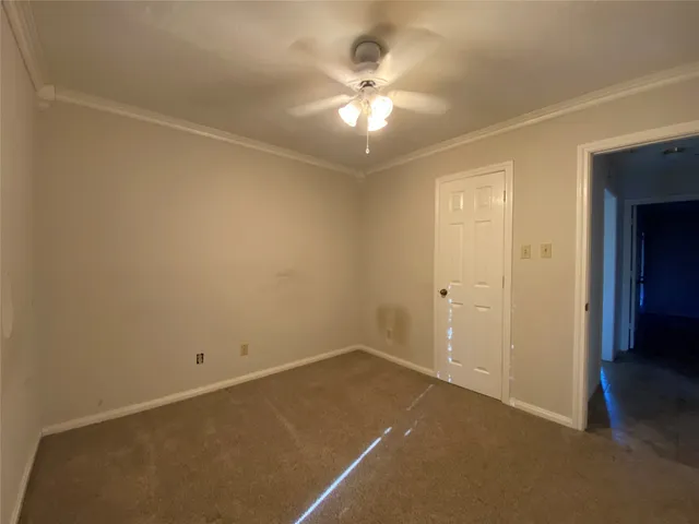 an empty room with a chandelier fan and closet area