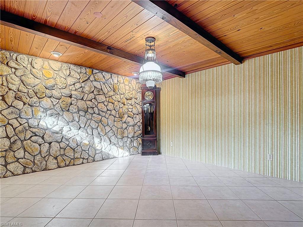 3550 11th Avenue Southwest Naples, FL 34117 - Photo 14 of 35 Tiled dining room featuring beam ceiling, wooden ceiling, and an inviting chandelier