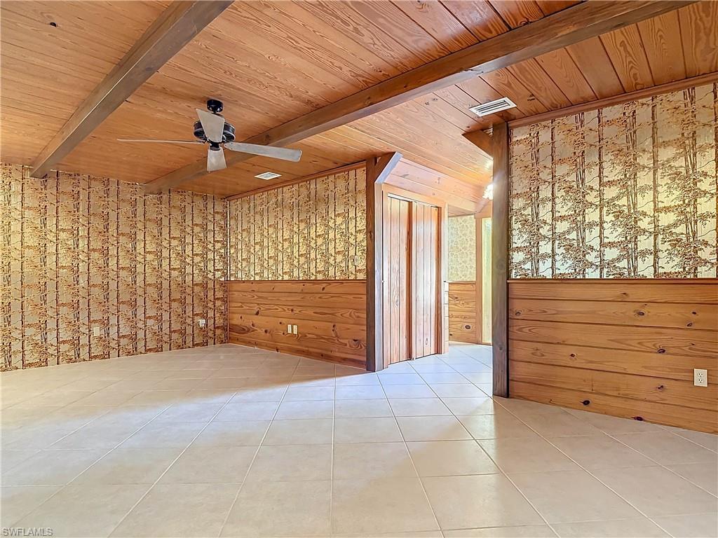 3550 11th Avenue Southwest Naples, FL 34117 - Photo 19 of 35 Parlor room featuring beam ceiling, ceiling fan, wooden ceiling, wood walls, and light tile patterned floors
