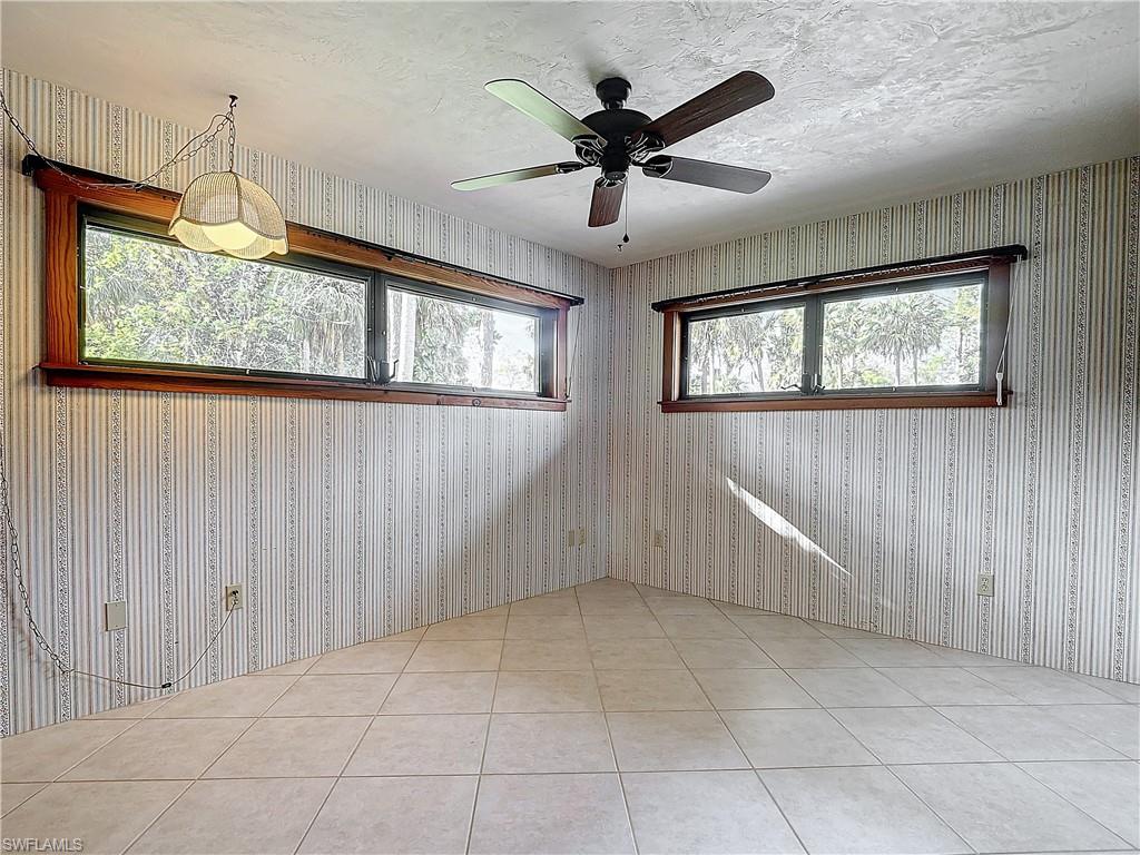 3550 11th Avenue Southwest Naples, FL 34117 - Photo 22 of 35 Guest bedroom 2 featuring light tile patterned floors, a textured ceiling, and ceiling fan