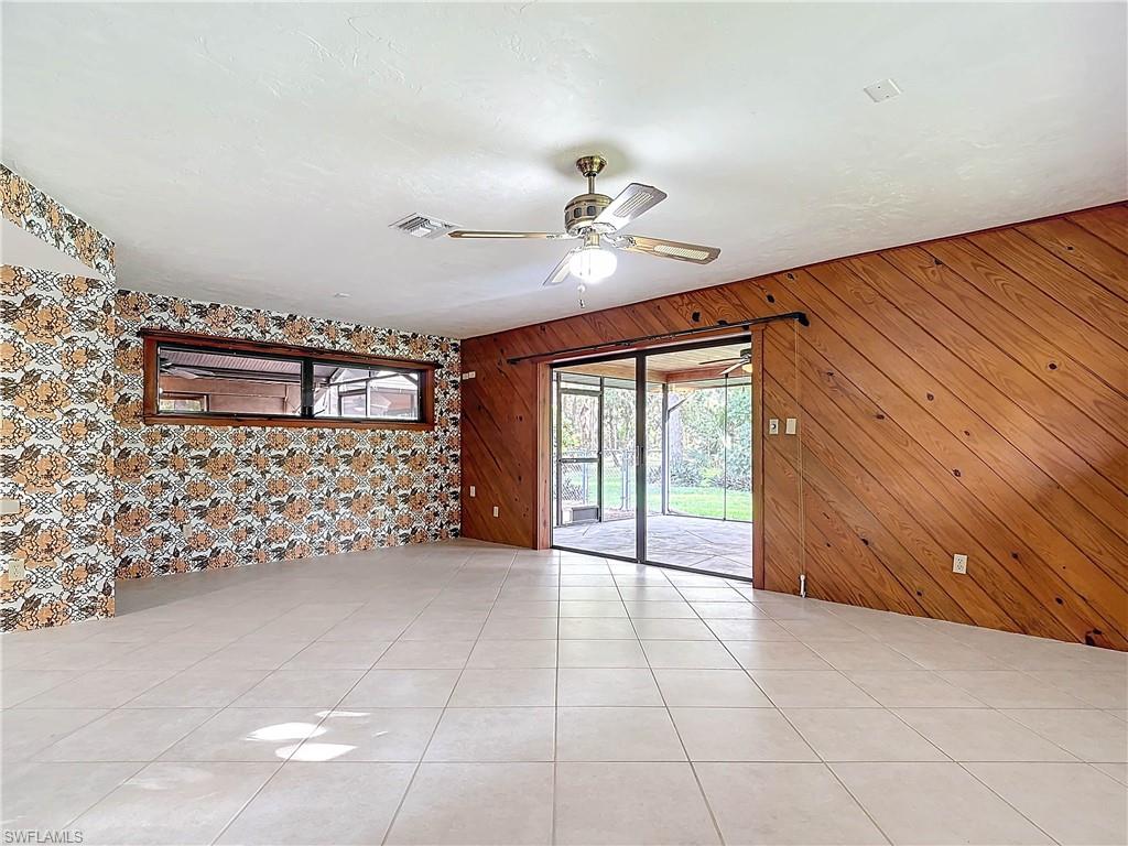 3550 11th Avenue Southwest Naples, FL 34117 - Photo 26 of 35 Tiled Master Bedroom with wood walls and ceiling fan