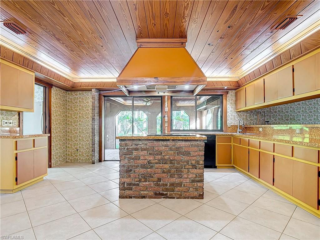 3550 11th Avenue Southwest Naples, FL 34117 - Photo 10 of 35 Kitchen with sink, wooden ceiling, custom range hood, and light tile patterned floors