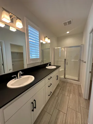 a spacious bathroom with a double vanity sink and a mirror