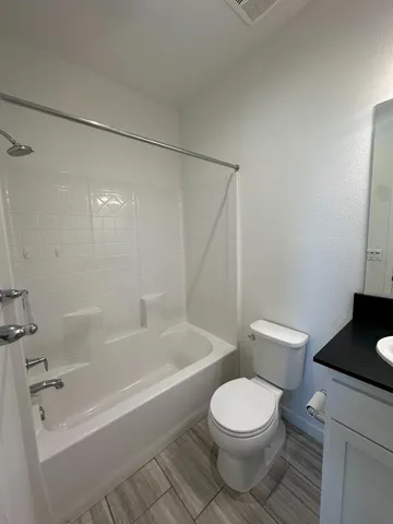 a white toilet and tub sitting next to a bathroom sink