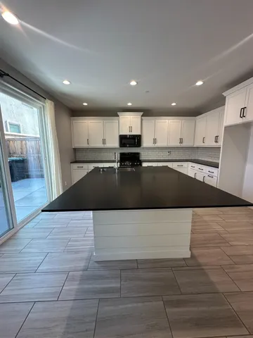 a kitchen with granite countertop a sink and a stove top oven