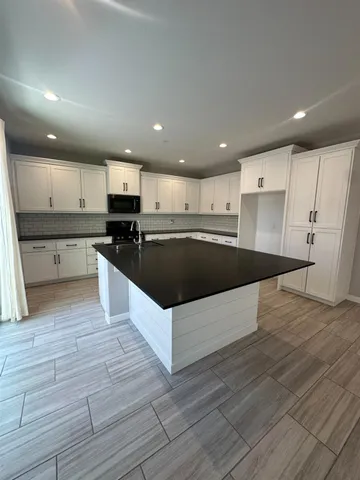 a large kitchen with stainless steel appliances granite countertop a large counter top and a stove top oven
